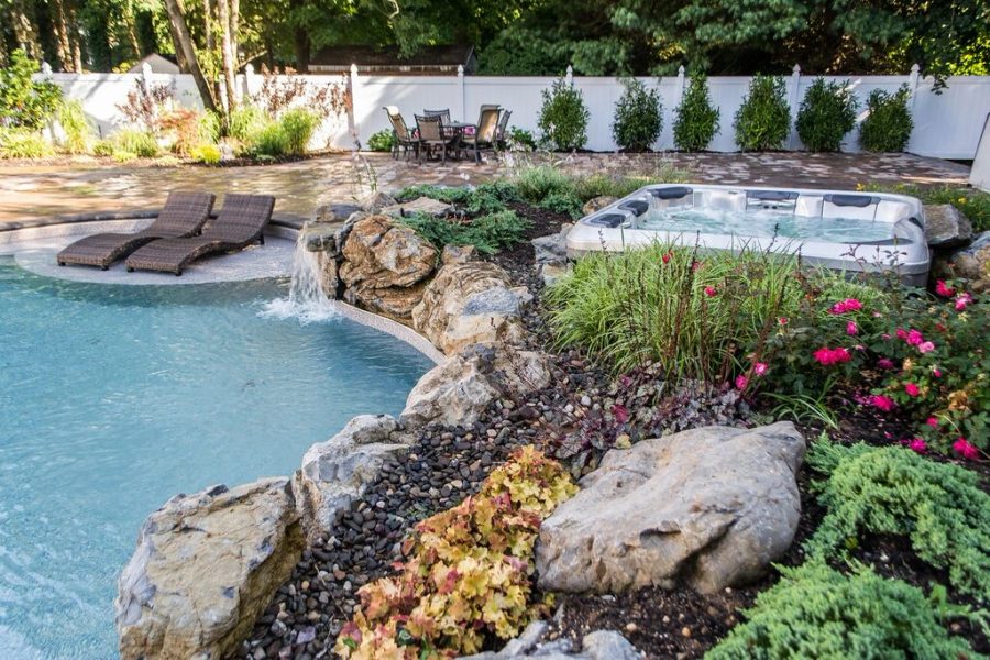Spa and pool with a natural boulder waterfall surround