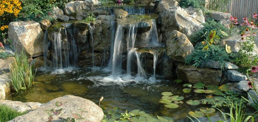 Multi-tier stone waterfall spilling into a rock-edged basin