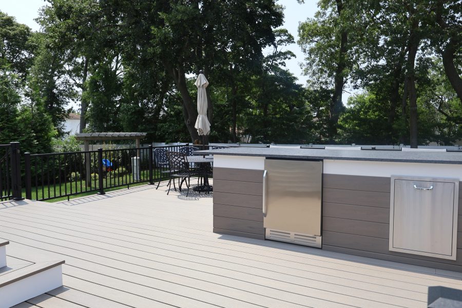 Outdoor kitchen counter with bar seating and stainless appliances