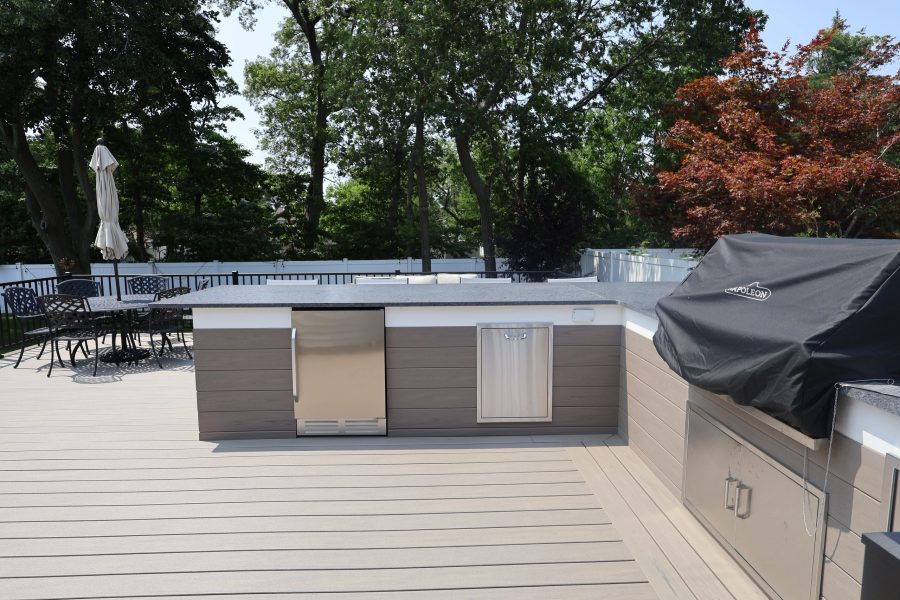 Masonry outdoor kitchen island with counter space and appliances