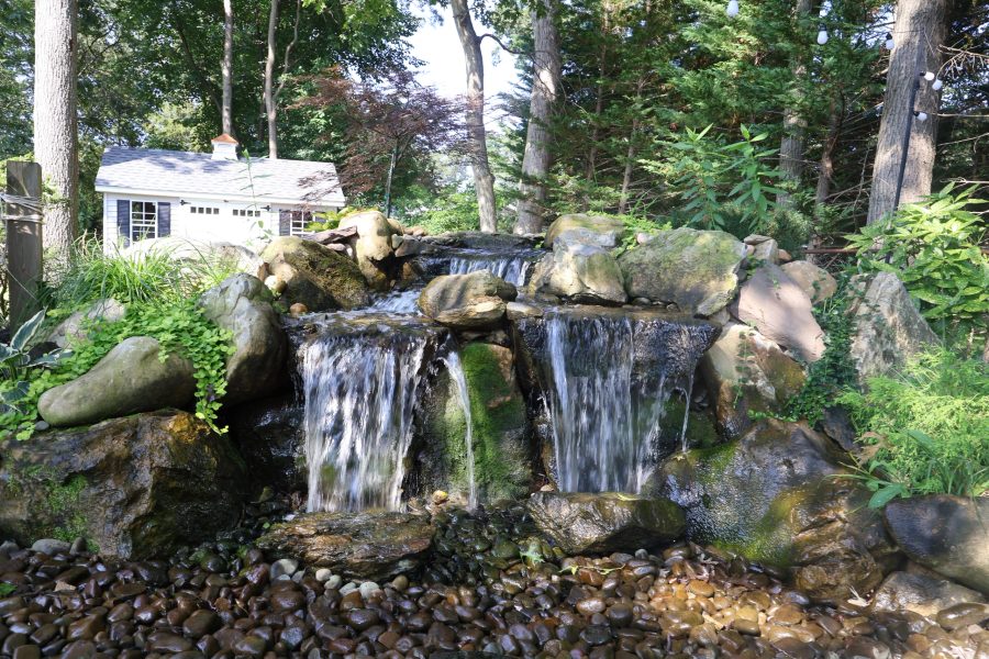 Stream bed and cascade set into boulders beside a home