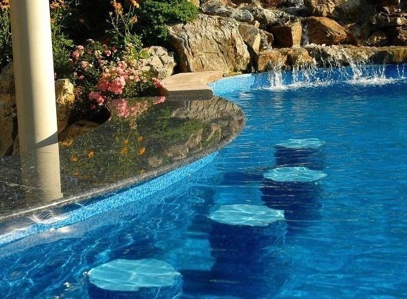Freeform pool with boulder waterfall and swim-up seating
