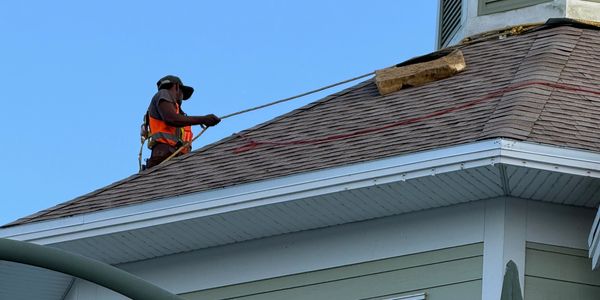 roofer working and tied off with harness