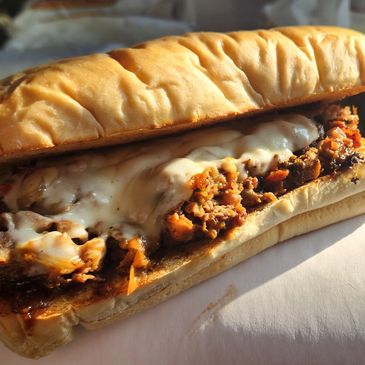 Cheesesteak sandwich with melted cheese and seasoned meat.