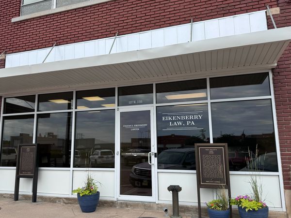 Exterior of Eikenberry Law office with large windows and flower pots.