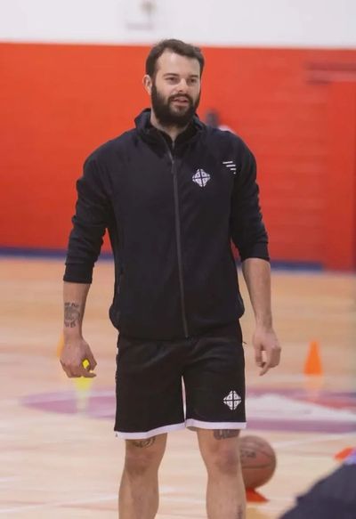 Man in sportswear standing on a basketball court.