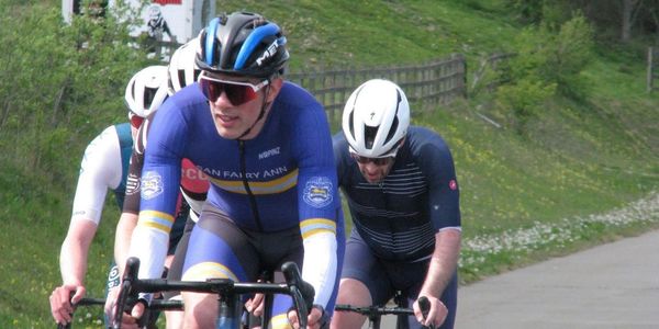 Cyclists racing on a rural road in competitive gear.