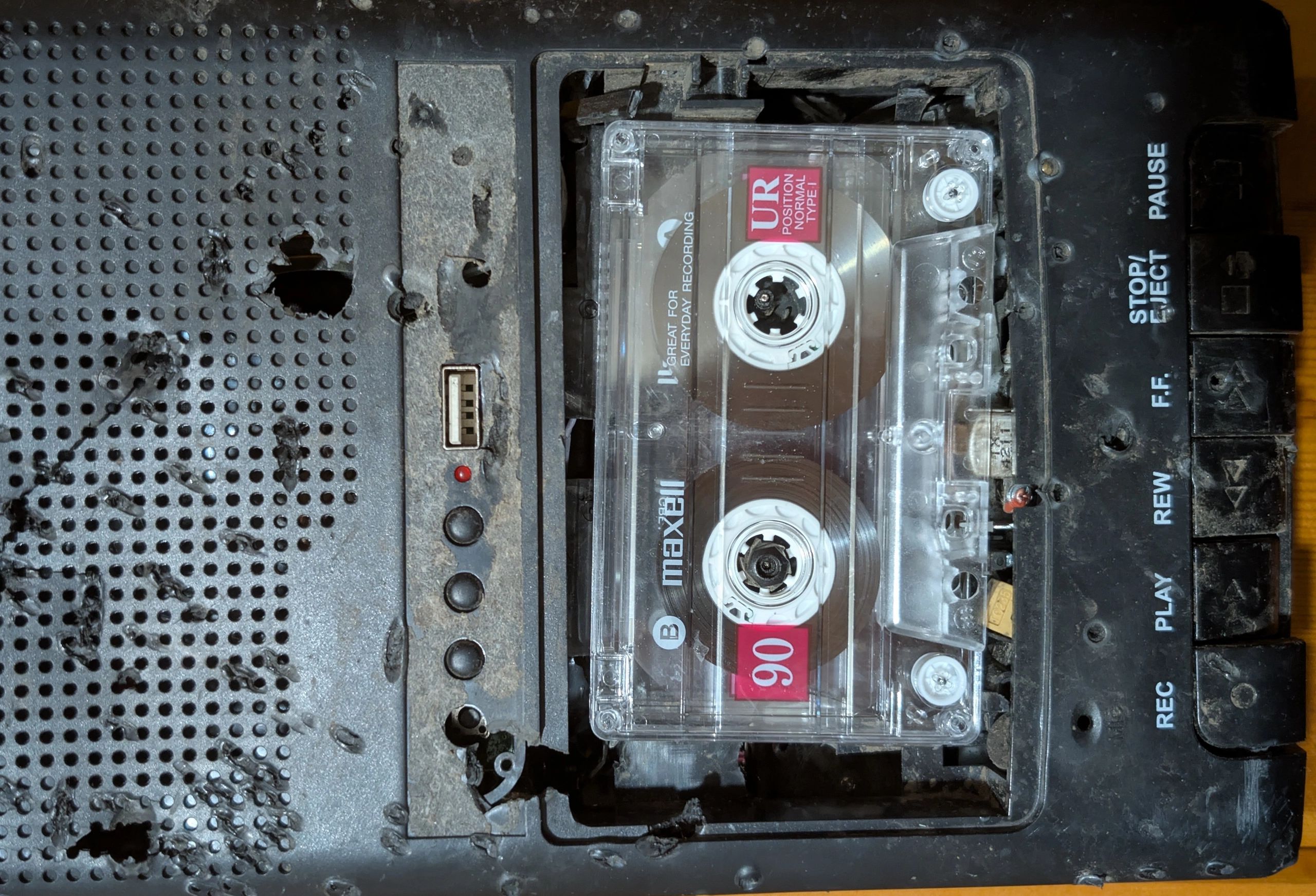 Worn-out cassette player with a Maxell tape inside.