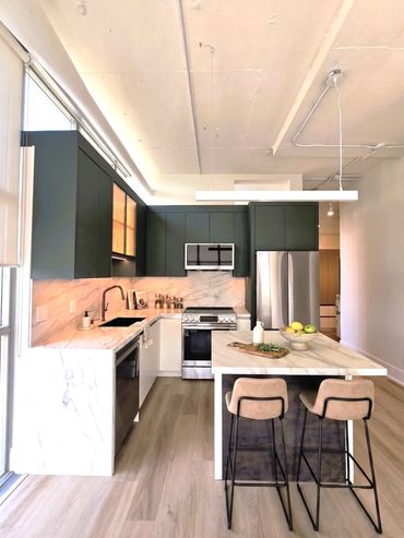 Modern kitchen with marble surfaces and bar stools.