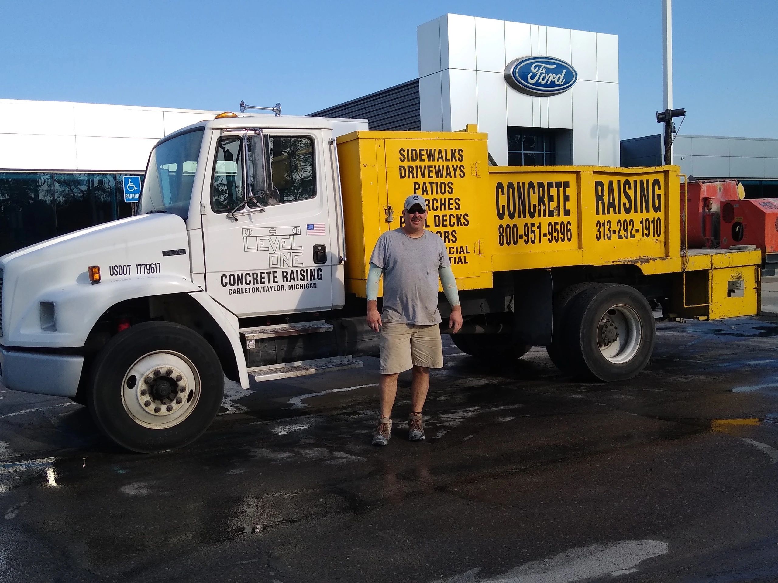 Man standing in front of a concrete raising truck with business details.