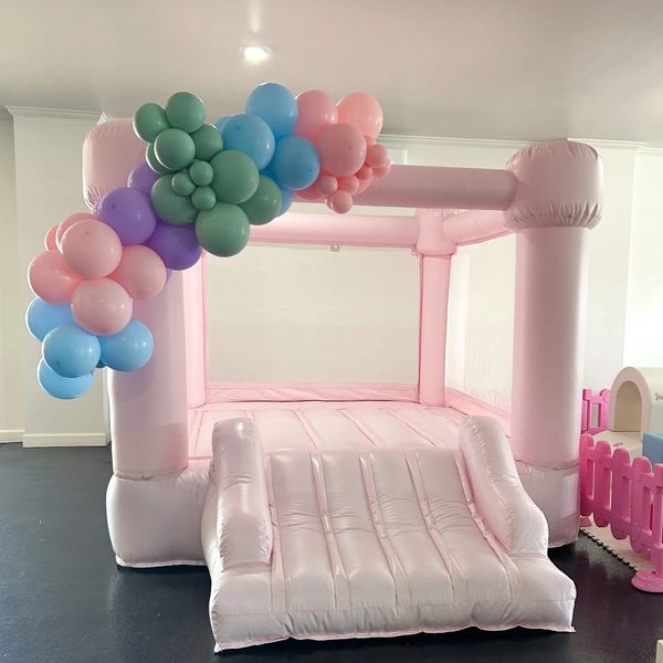 Pink inflatable bounce house with colorful balloon decoration.