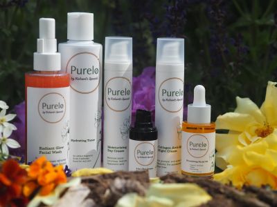 A collection of Purelo skincare products displayed with flowers and natural elements.