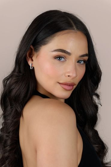 Elegant woman with dark hair and blue eyes posing with a soft smile.