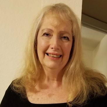 Smiling middle-aged woman with blonde hair.