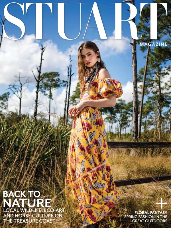 Woman in a floral yellow dress posing outdoors for Stuart Magazine.