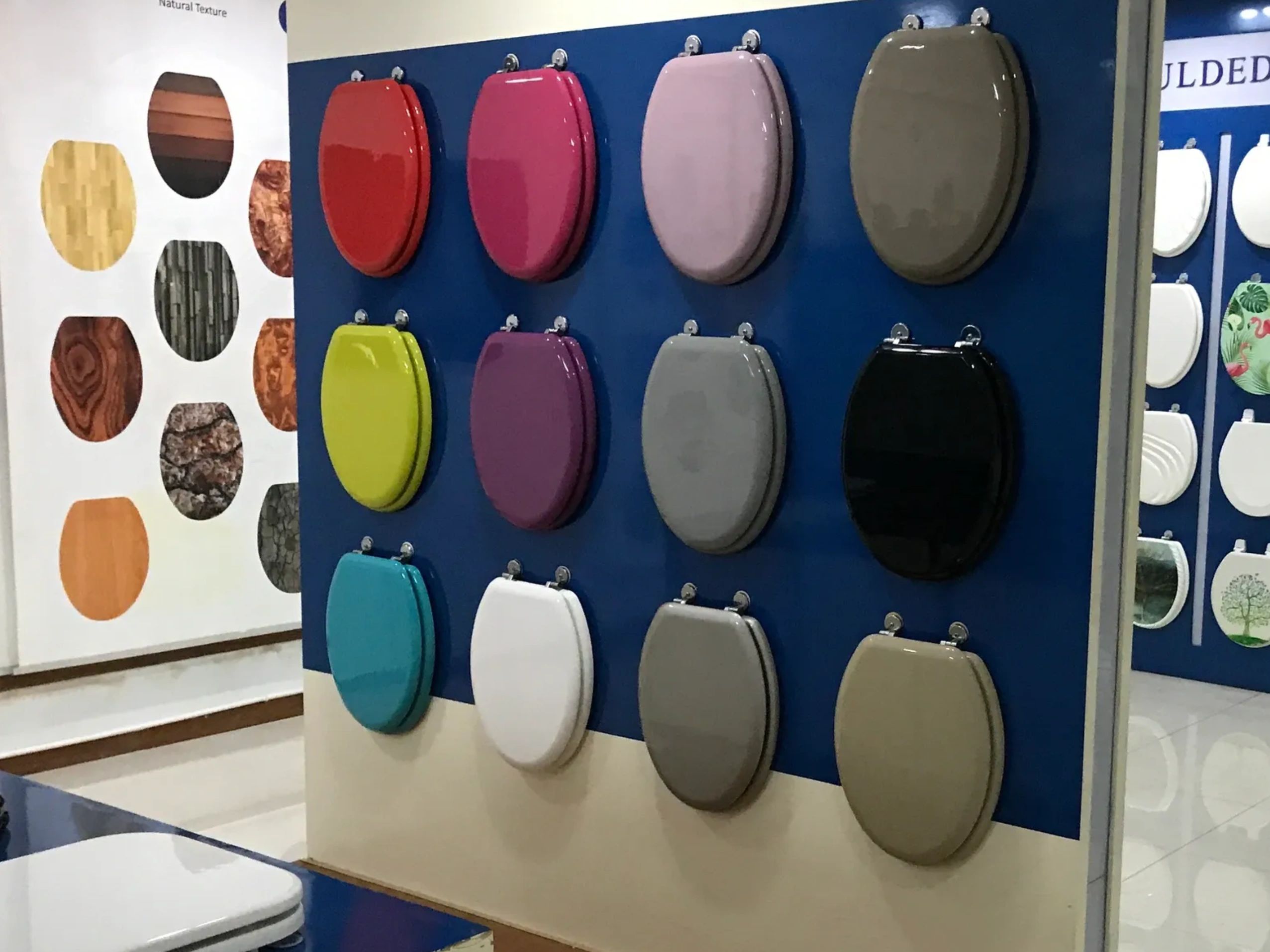Wall of varying colored customized toilet seats.