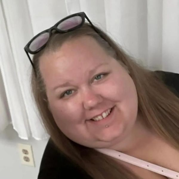 Smiling woman with glasses on her head.