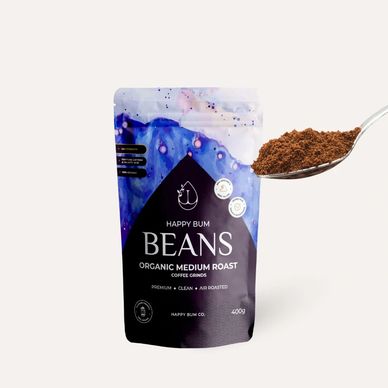 Happy Bum organic medium roast coffee grounds with a spoonful of coffee.