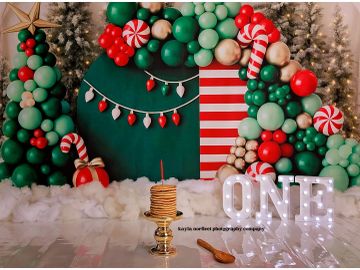 Festive first birthday setup with balloons, lights, and a stack of pancakes.