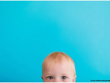 Close-up of a child's head against a blue background.