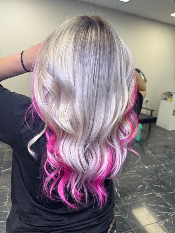 Long silver hair with vibrant pink tips styled in loose waves.