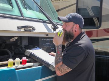 RV inspector doing and performing a fluid analysis for a motorhome