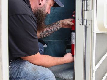 RV Inspector doing and safety inspection on a fire extinguisher