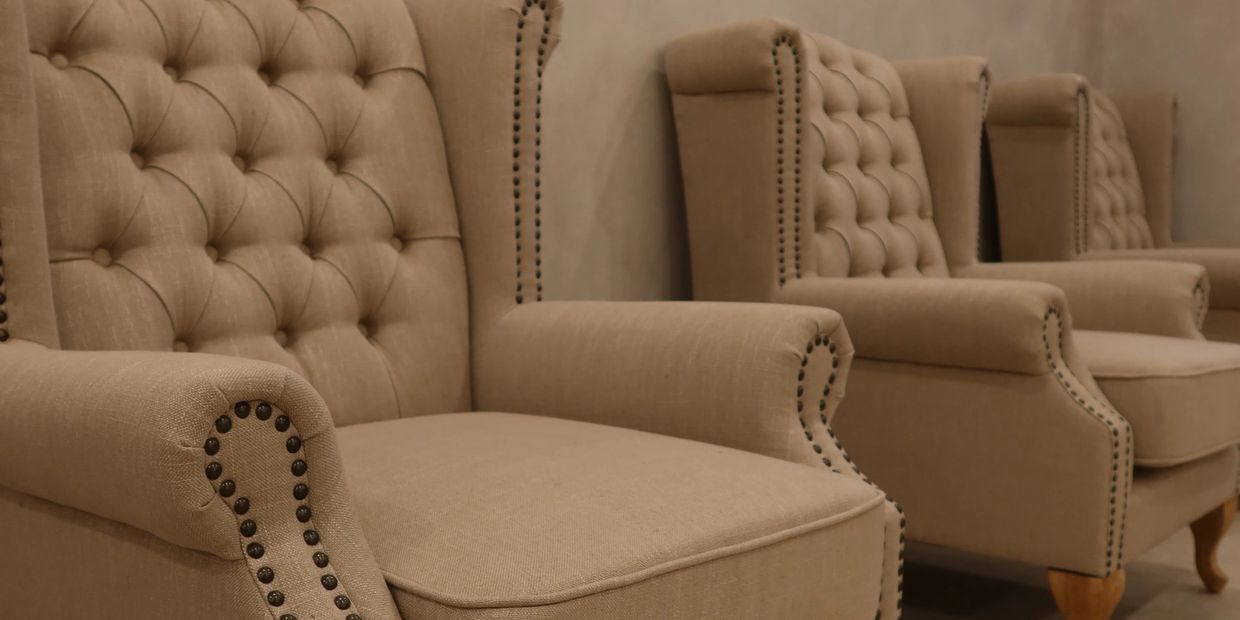 Row of elegant beige tufted armchairs.