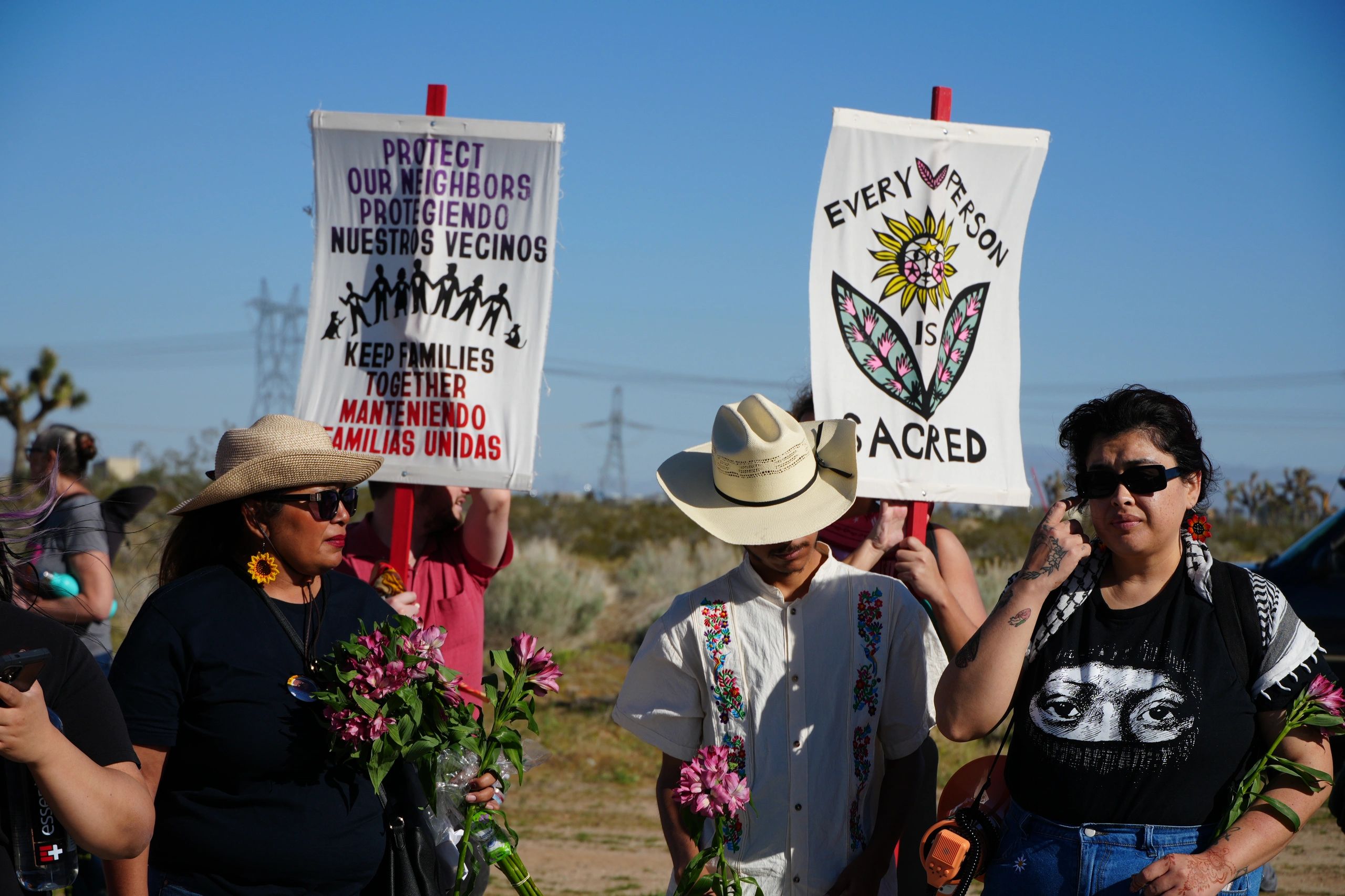 People holding signs advocating for family unity and sacredness of every person.