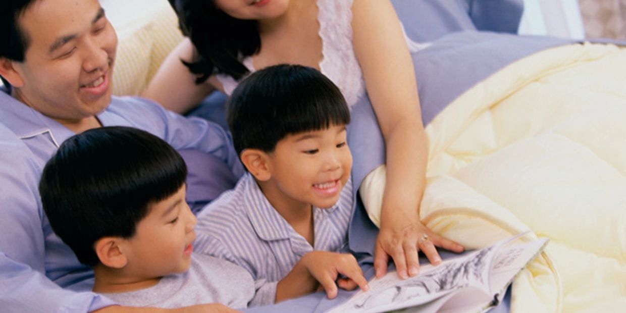 Two boys happily reading a book.