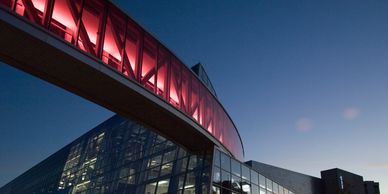 Modern building with a red-lit skybridge at dusk.