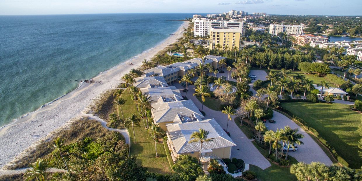 Aerial view of beachfront buildings and greenery.