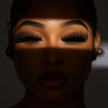 Face in shadow with dramatic eyelashes and closed eyes.