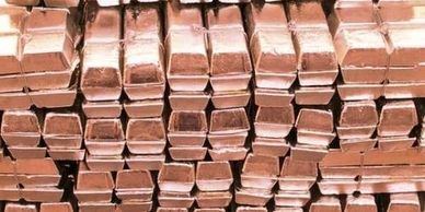 Stacked copper bars arranged in neat rows.