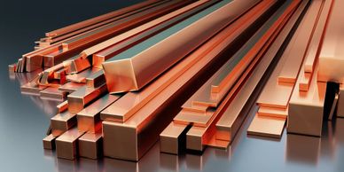 Various copper bars in different shapes and sizes arranged together.
