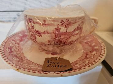 Vintage teacup and saucer with a Kona Coffee tag wrapped in plastic.