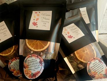 Black packages of Warm Home Simmering Pot Mix with dried orange slices.