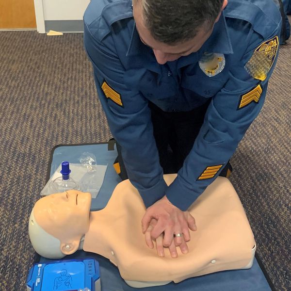 a man practicing CPR on a mannequin