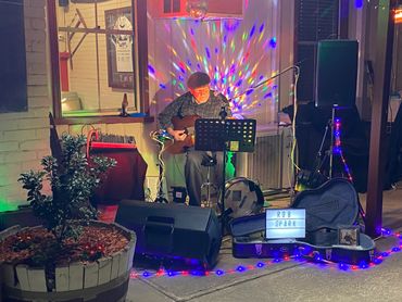A musician named Rob Spark performing with guitar and colorful lights.