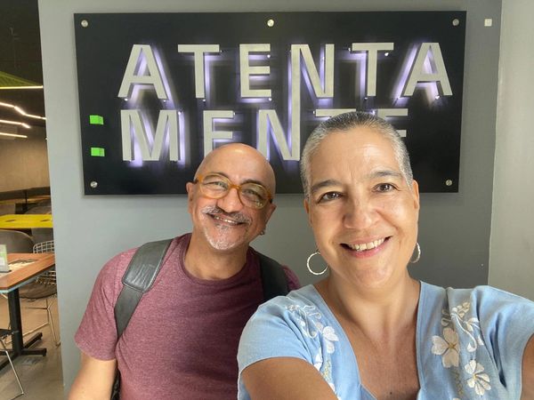 Dos personas frente al letrero del Cafe Atentamente