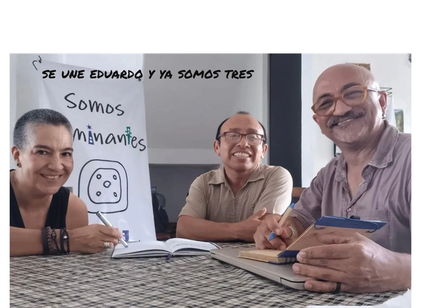 los tres integrantes de la asociación trabajando sobre una mesa y sonriendo
