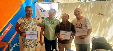 Cuatro personas posando con certificados en la mano.