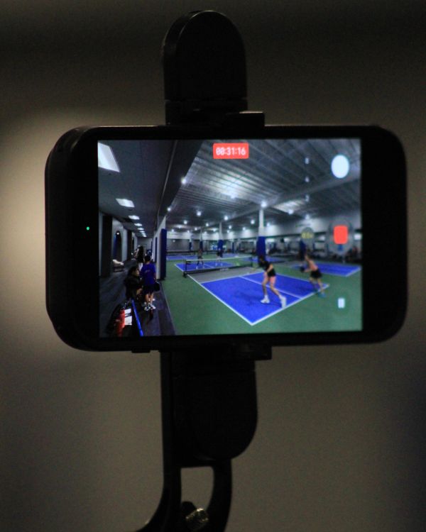 Phone screen recording indoor pickleball game.