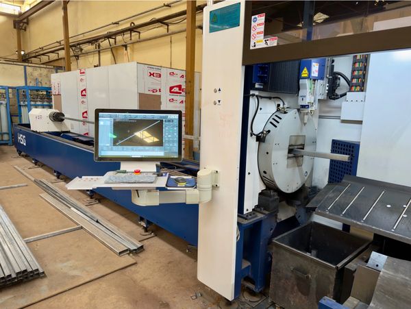 High-tech CNC machine setup for metal tube processing in an industrial workshop.