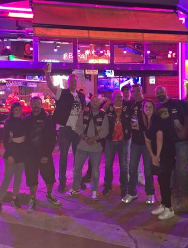 Group of friends posing at night under neon lights