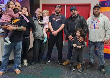 Group of men with children posing indoors.