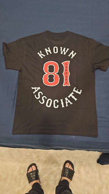Black t-shirt with "Known Associate 81 Support" design.