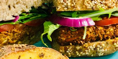 Close-up of a veggie burger with fresh veggies and sesame seed bun.