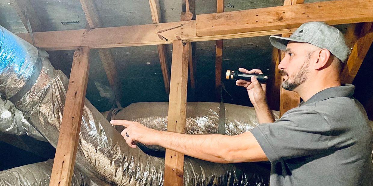 Houston CLM home inspection inspector checking the HVAC ducts in an attic 