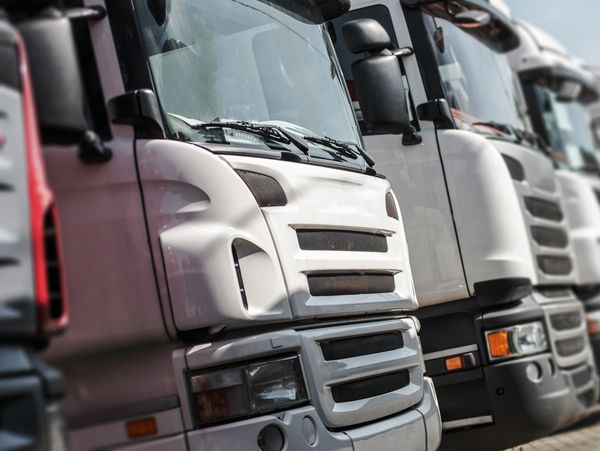 A row of parked trucks lined up closely together.